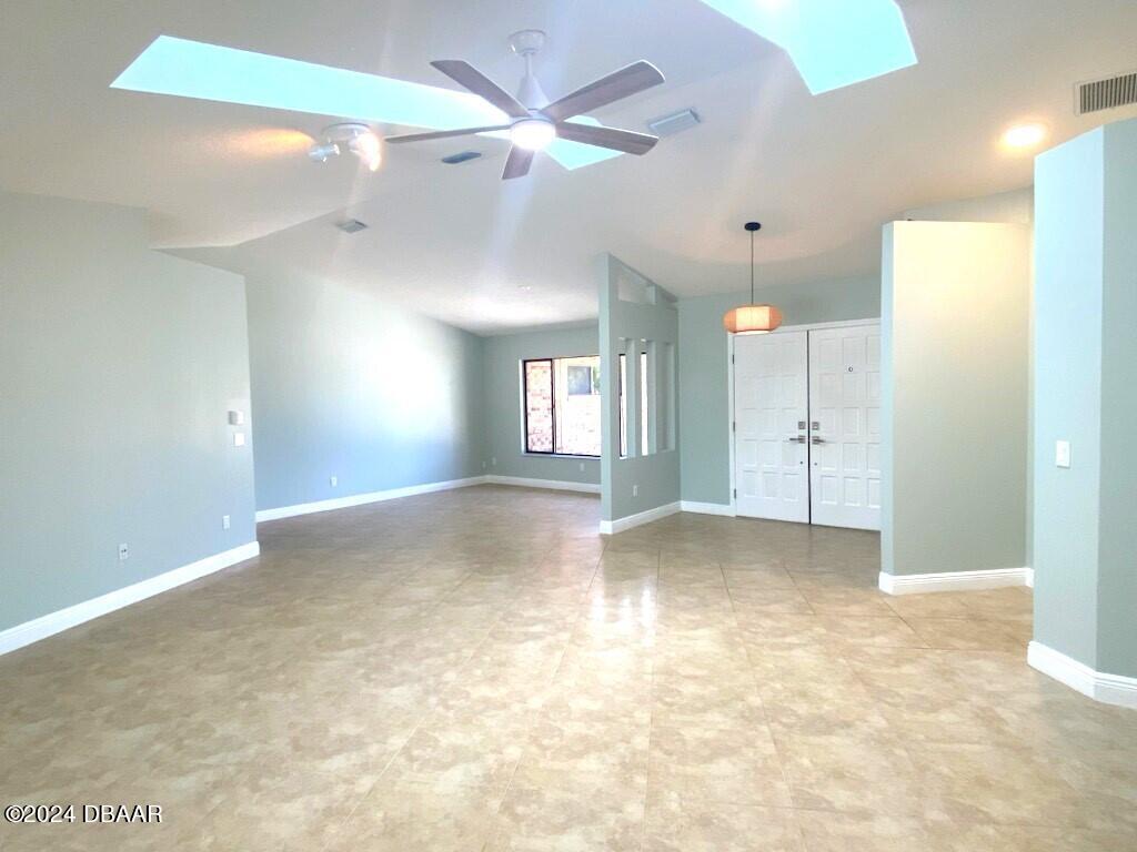 12 Julie Drive Ormond Beach, FL 32176 - Photo 4 of 24 a view of empty room with a ceiling fan and kitchen view