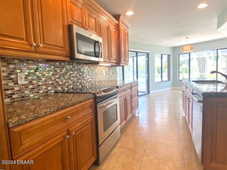 12 Julie Drive Ormond Beach, FL 32176 - Photo 8 of 24 a kitchen with stainless steel appliances granite countertop a stove a sink and a microwave