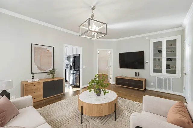 a living room with furniture a flat screen tv and kitchen view