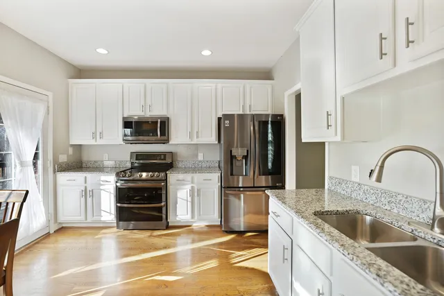 a view of a white house next to a road and yard