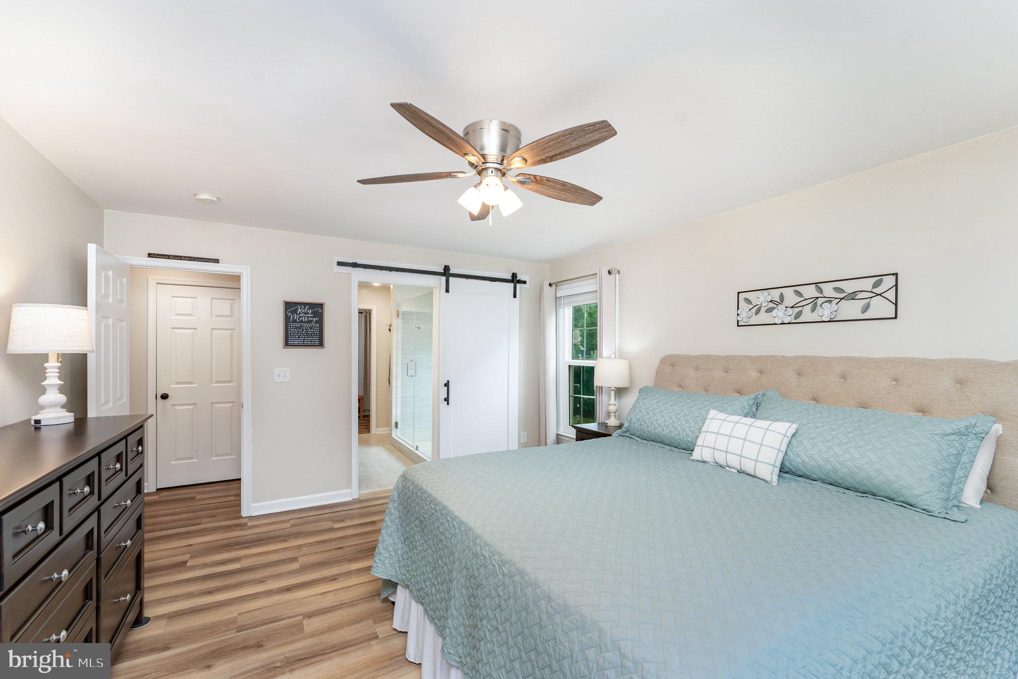 102 Parliament Street Locust Grove, VA 22508 - Photo 16 of 29 a spacious bedroom with a bed and a chandelier
