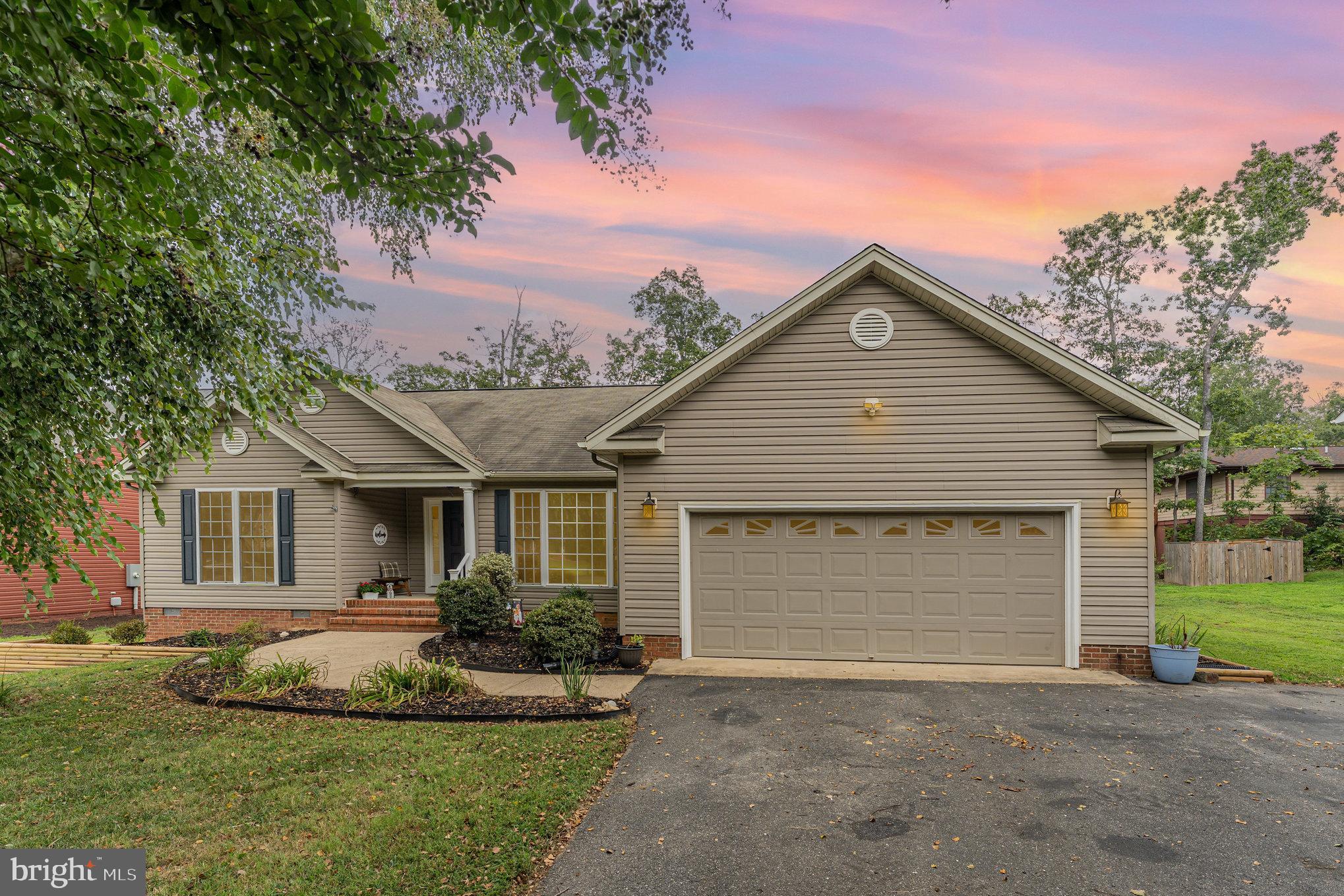 102 Parliament Street Locust Grove, VA 22508 - Photo 2 of 29 a front view of a house with a garden and yard