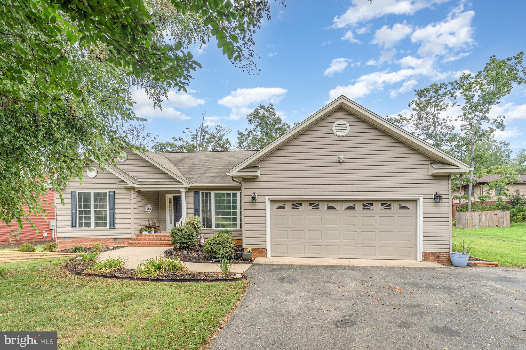 102 Parliament Street Locust Grove, VA 22508 - Photo 3 of 29 a front view of a house with a garden and yard