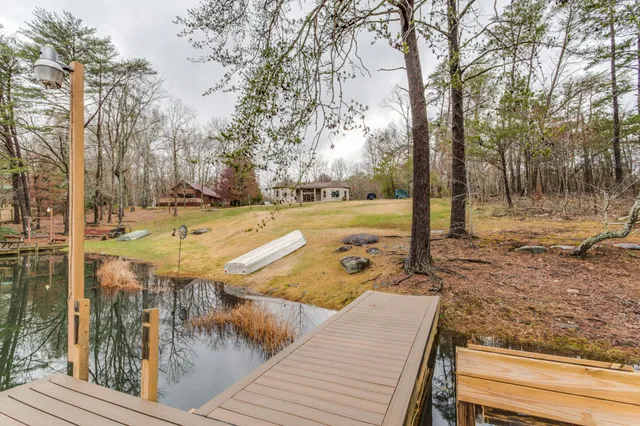 a view of swimming pool with a bench and trees