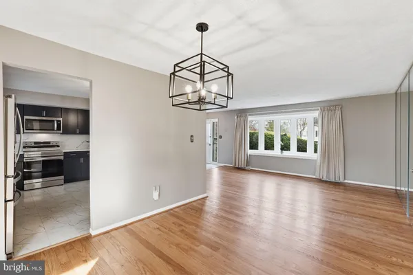 a view of a room with wooden floor kitchen view and a window