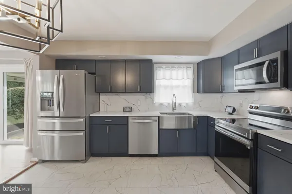 a kitchen with stainless steel appliances granite countertop a refrigerator stove a sink and dishwasher