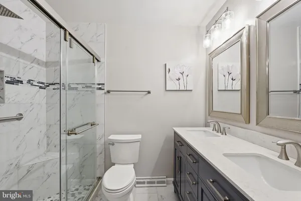 a bathroom with a granite countertop sink toilet and shower