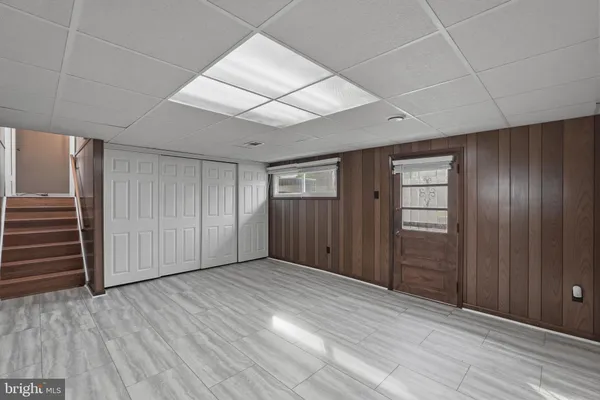 an empty room with wooden floor & windows and closet