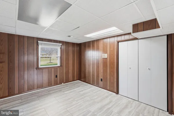 a view of an empty room with closet and entryway