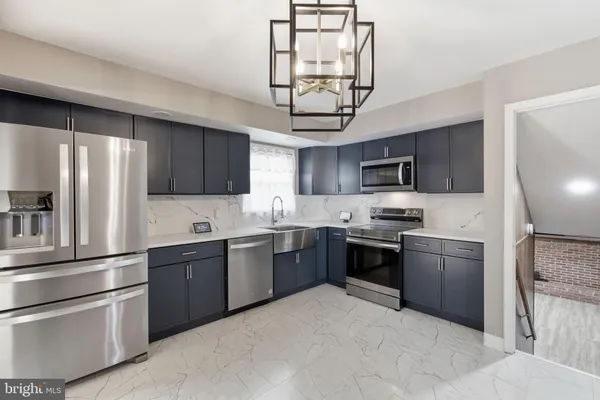 a kitchen with stainless steel appliances granite countertop a refrigerator stove a sink dishwasher and microwave