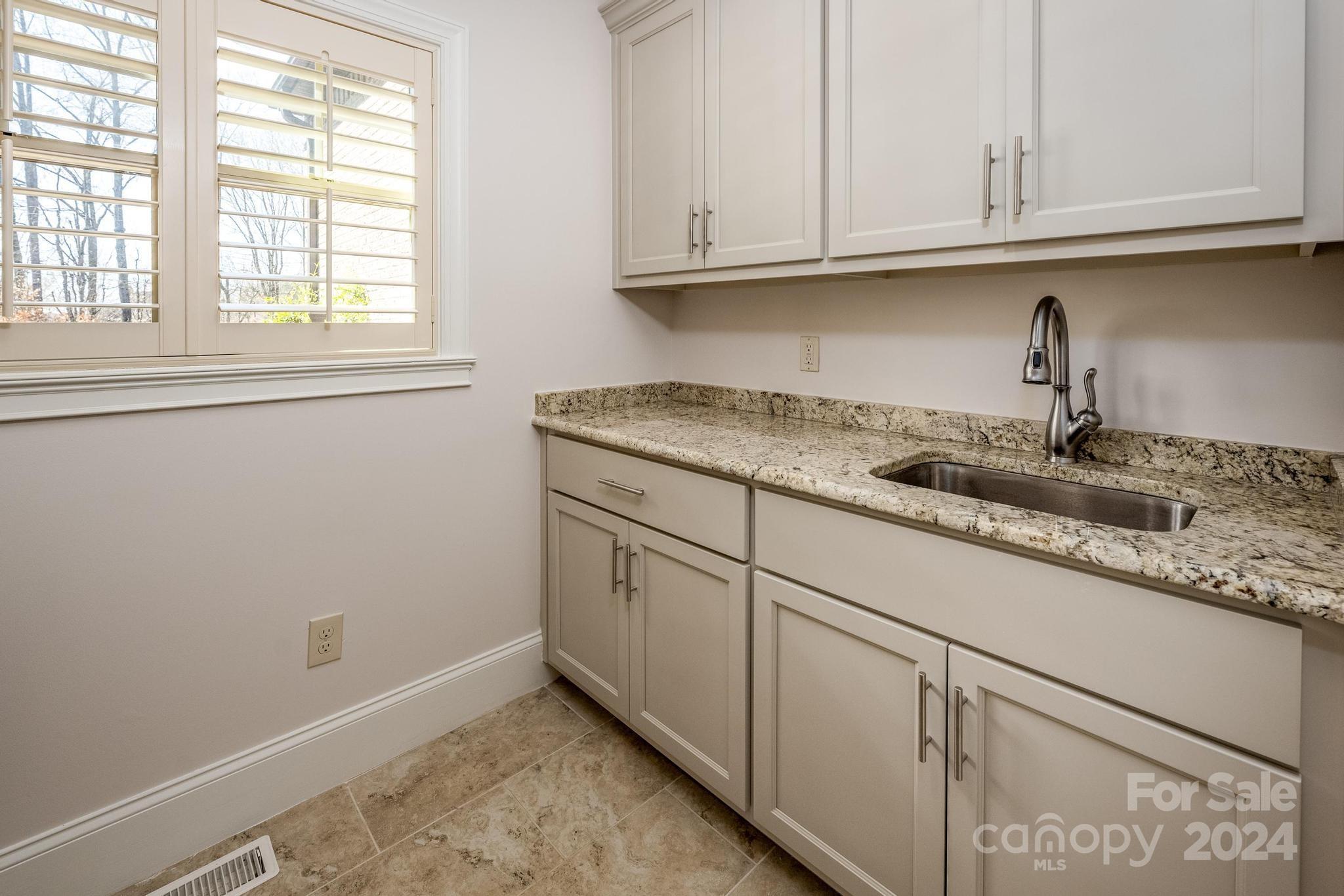 320 Barber Loop Mooresville, NC 28117 - Photo 34 of 44 a kitchen with granite countertop white cabinets and a window