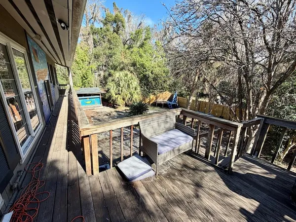 a view of deck with furniture and trees