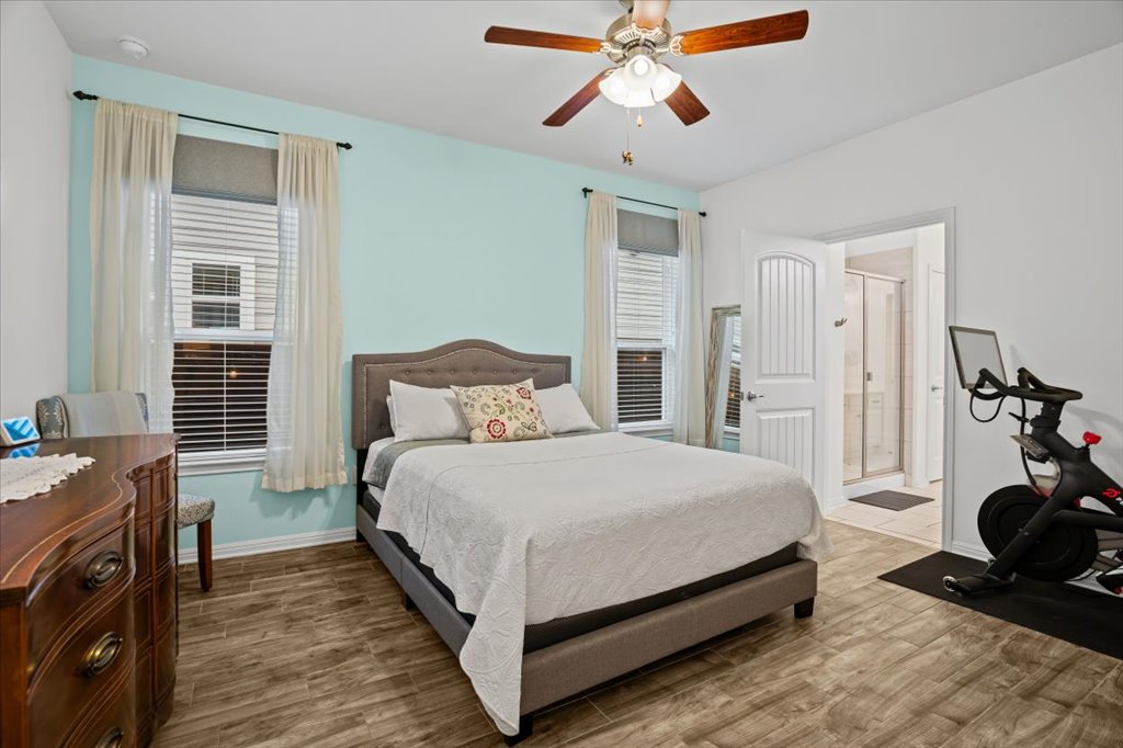 5912 Corrine Lane Austin, TX 78747 - Photo 11 of 27 Primary Bedroom featuring wood finished floors, ceiling fan, and primary bathroom