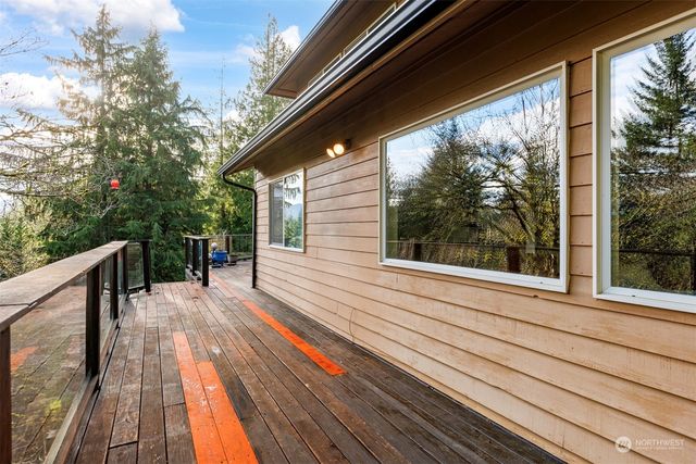 a view of balcony with wooden floor and fence next to a large window