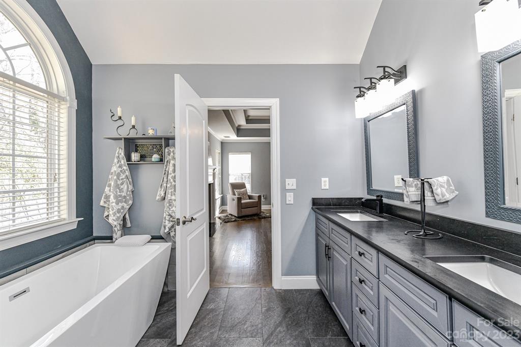 21311 Summerbrook Drive Cornelius, NC 28031 - Photo 16 of 28 a spacious bathroom with a granite countertop sink mirror and a bathtub