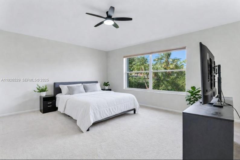 22065 Palm Grass Drive Boca Raton, FL 33428 - Photo 14 of 46 a bed sitting in a spacious bedroom next to a window