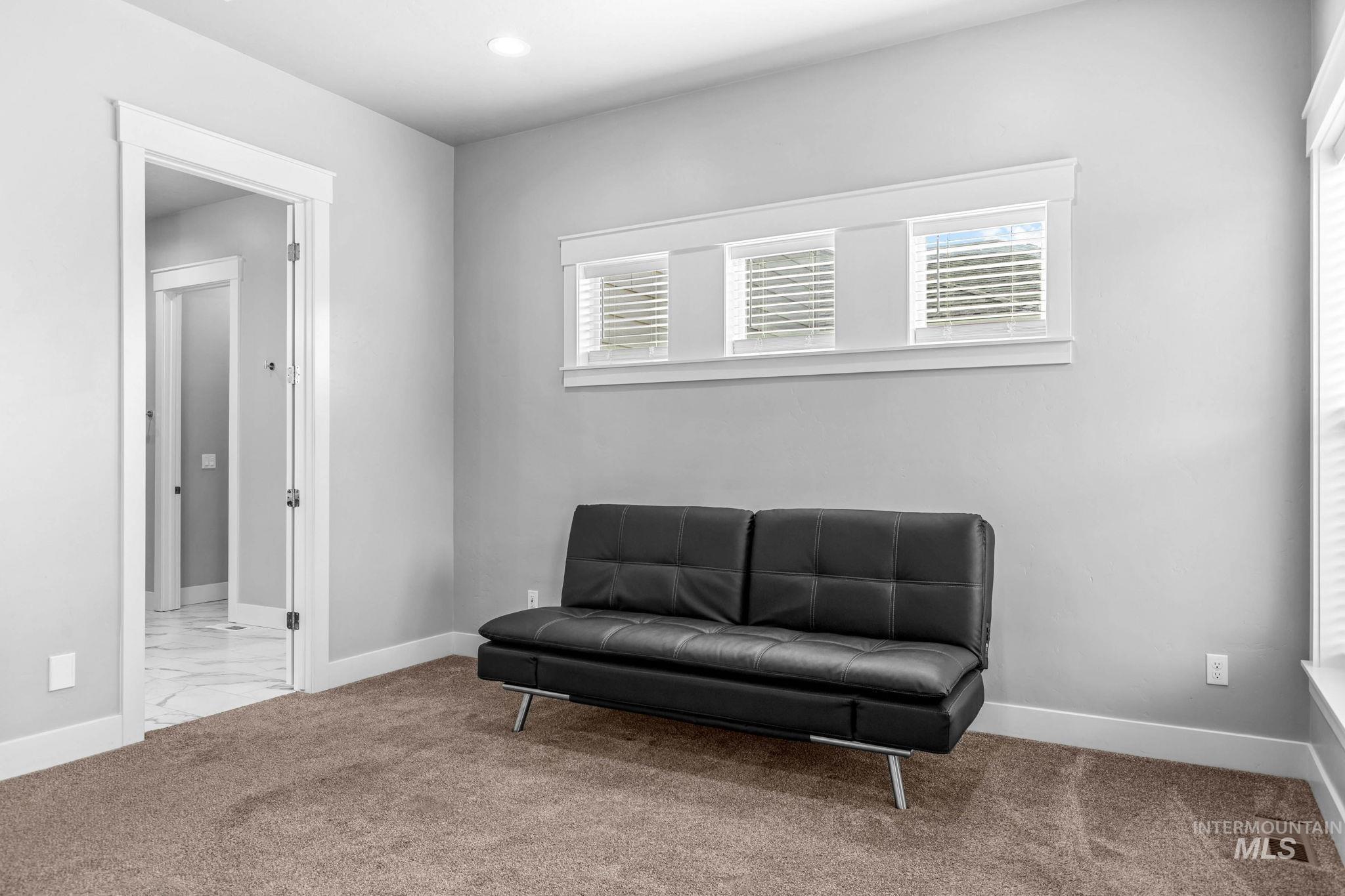 2934 East Murchison Street Meridian, ID 83642 - Photo 22 of 44 Recessed lighting illuminates this carpeted room featuring a white trim package, three transom windows with blinds, and an entryway with a glass-paneled door