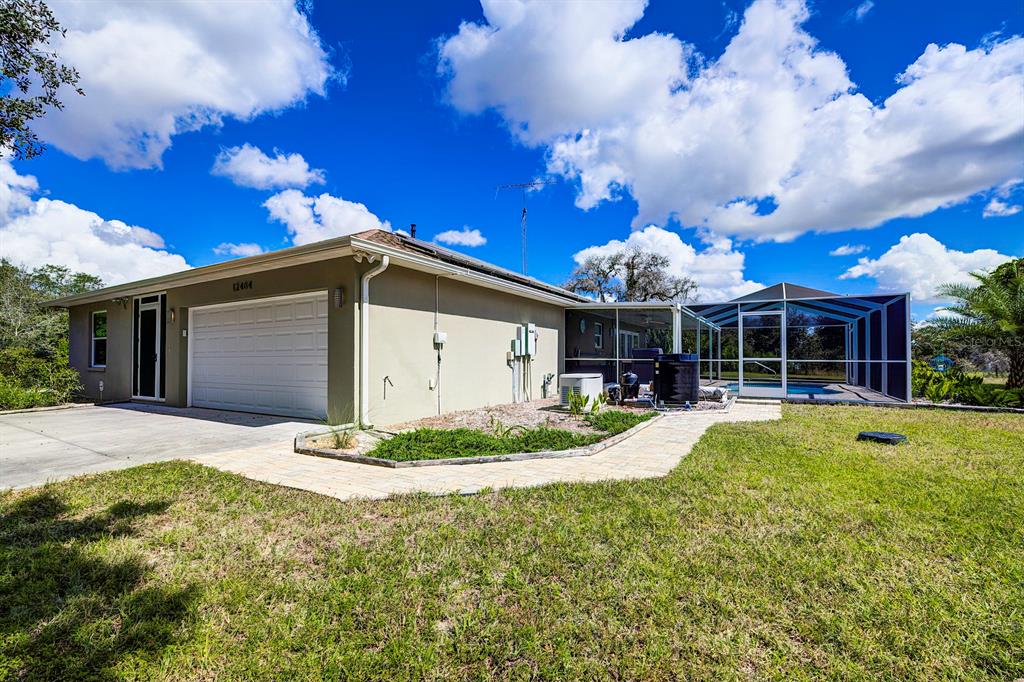 12404 Cumberland Road Weeki Wachee, FL 34614 - Photo 1 of 1 Front and side view. Take note of the whole house generator and pool heater.