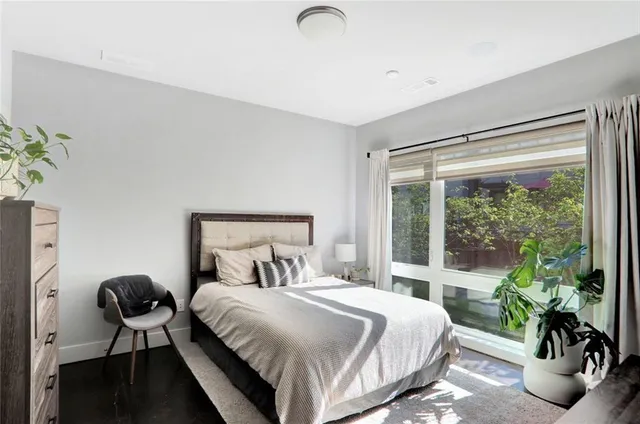 a large bed sitting in a bedroom next to a window
