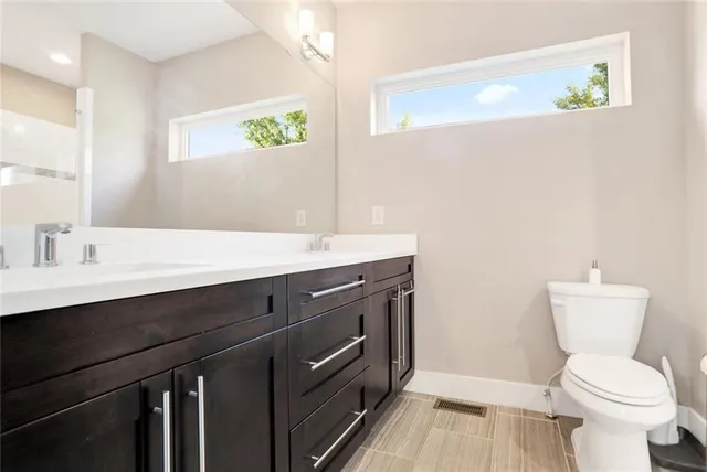 a bathroom with a sink a toilet a mirror and shower curtain