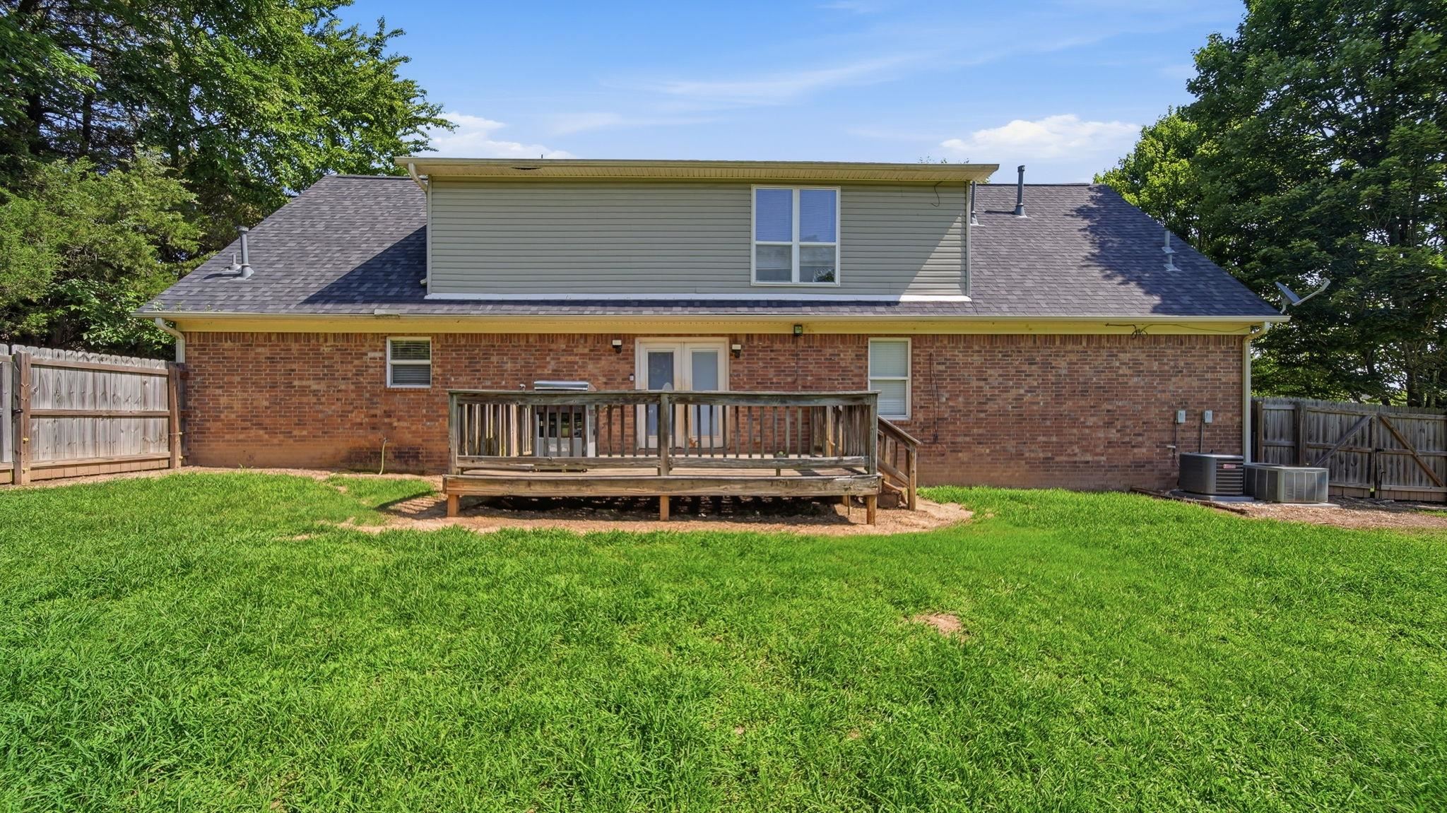 217 Rae Drive Munford, TN 38058 - Photo 34 of 40 Expansive fenced backyard featuring a two-story residence with a brick lower level and horizontal siding on the upper level