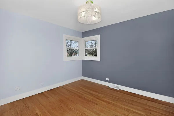 a view of a room with wooden floor and a window