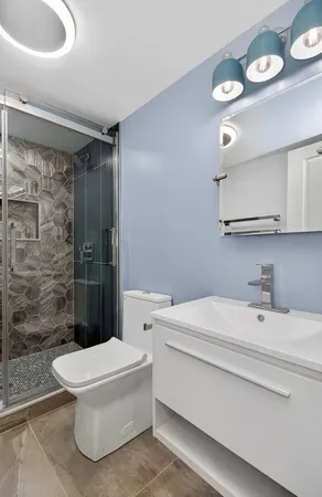 a bathroom with a sink a toilet and shower