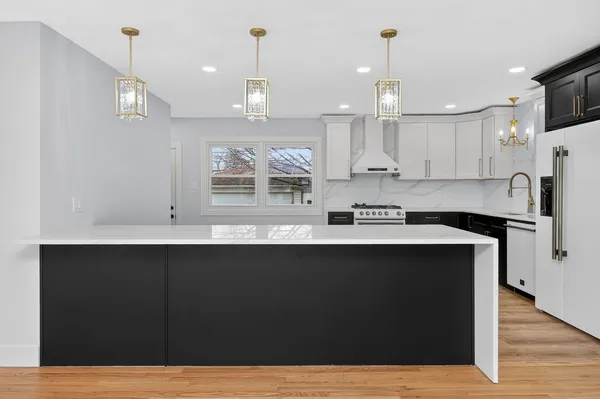 a kitchen with kitchen island a sink stainless steel appliances and cabinets