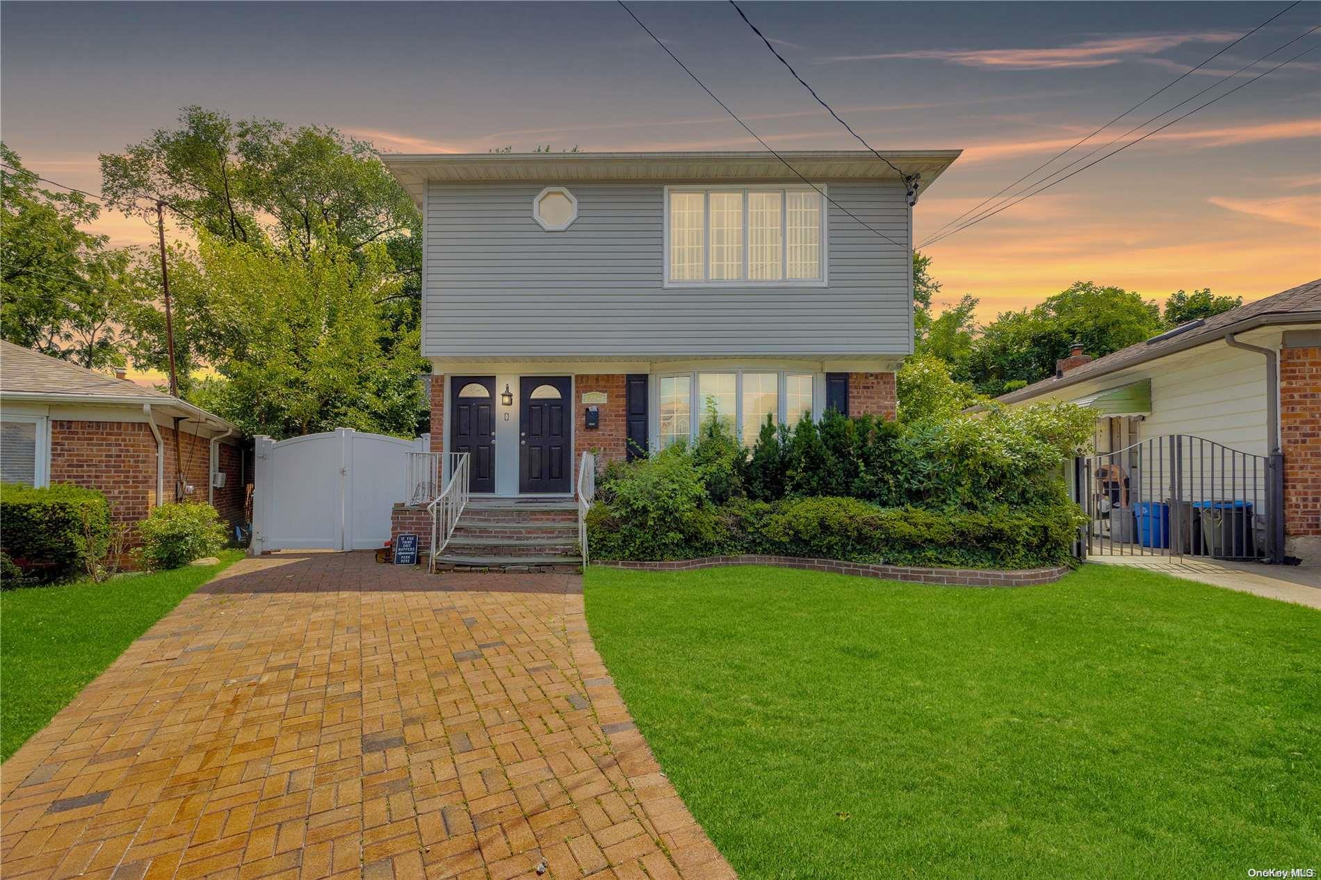 a front view of a house with a yard and trees