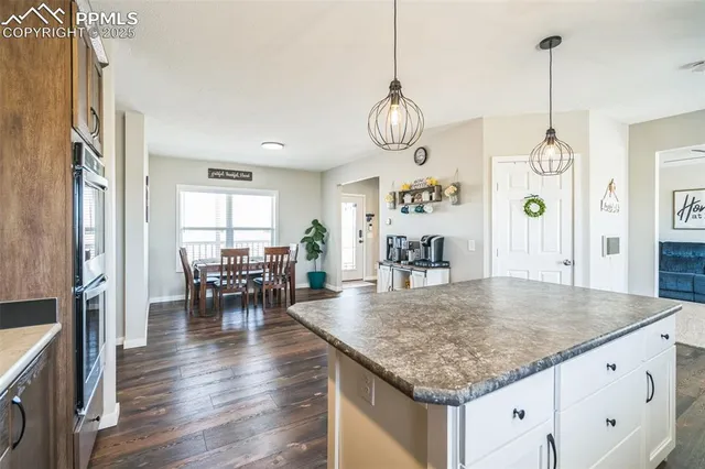 an open kitchen with granite countertop a table chairs and couches