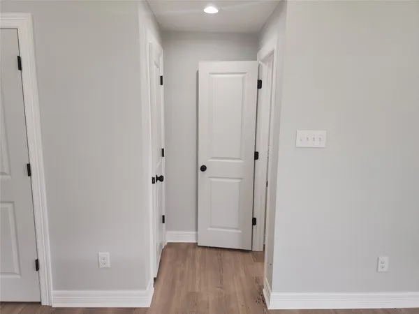 a view of a hallway with wooden floor