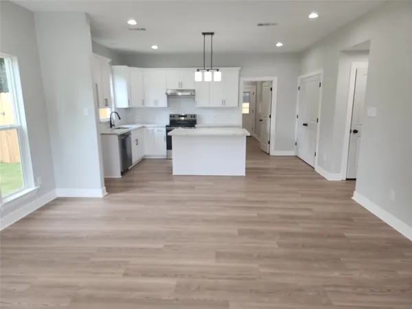 a large kitchen with granite countertop a large counter top stainless steel appliances and cabinets