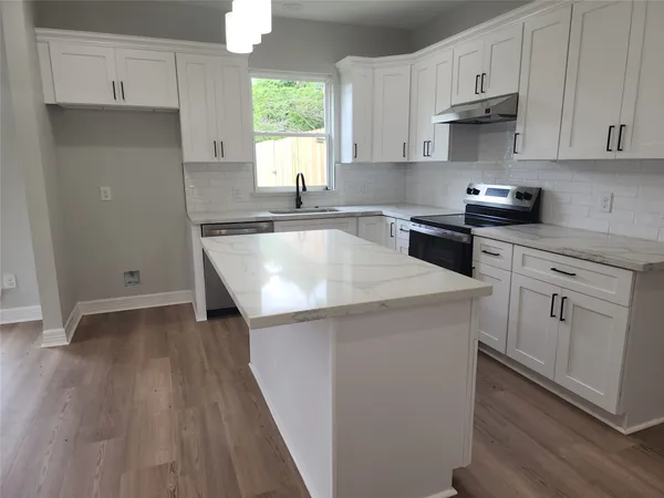 a kitchen with granite countertop white cabinets and white appliances