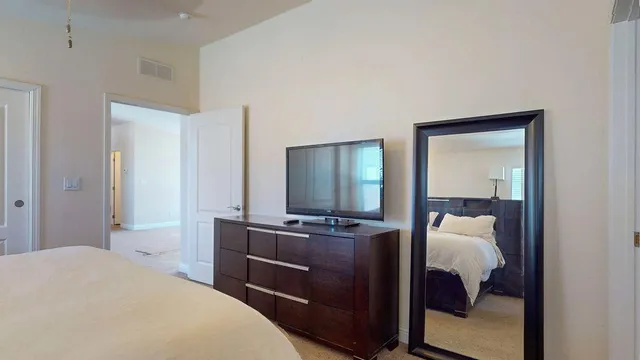 a bedroom with a bed and painting on the wall