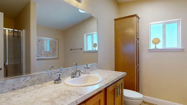 a en suite bathroom with a granite countertop sink and a mirror