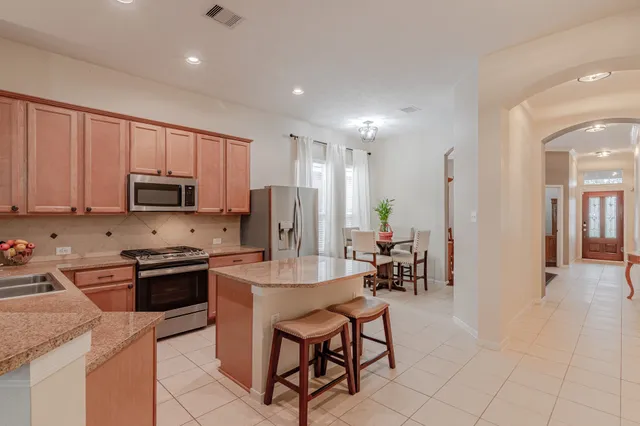 a kitchen with stainless steel appliances granite countertop a stove a sink a refrigerator and a microwave