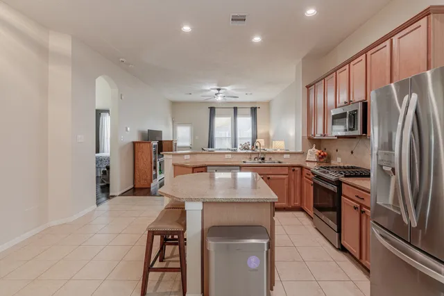 a kitchen with stainless steel appliances granite countertop a refrigerator a stove top oven a sink and dishwasher