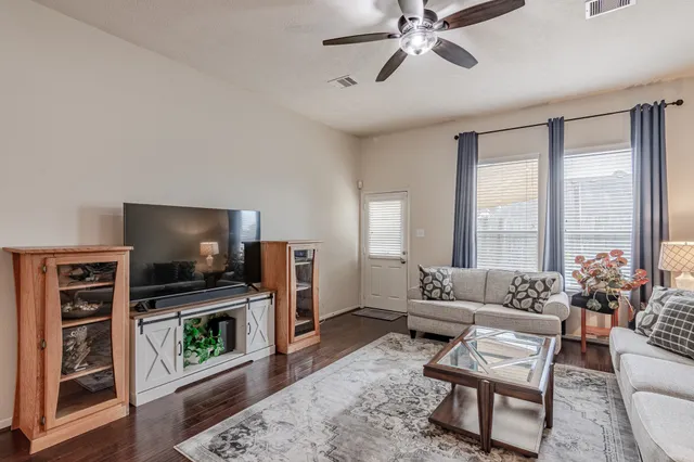 a living room with furniture a flat screen tv and a fireplace