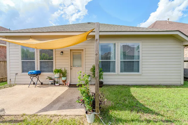 a view of a house with backyard and sitting area
