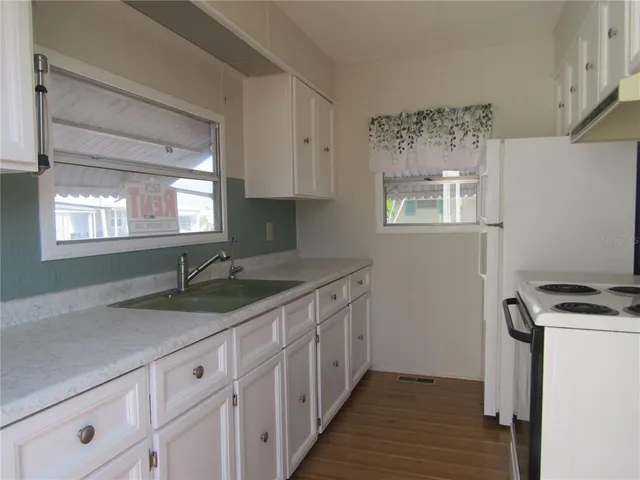 a kitchen with granite countertop cabinets stainless steel appliances a sink and a window