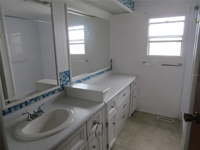 a bathroom with double sink and a mirror