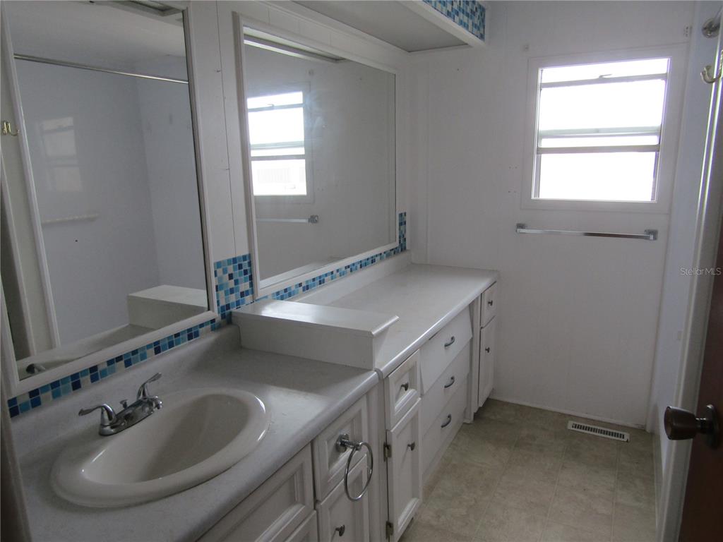 721 Roma Road Venice, FL 34285 - Photo 7 of 20 a bathroom with double sink and a mirror