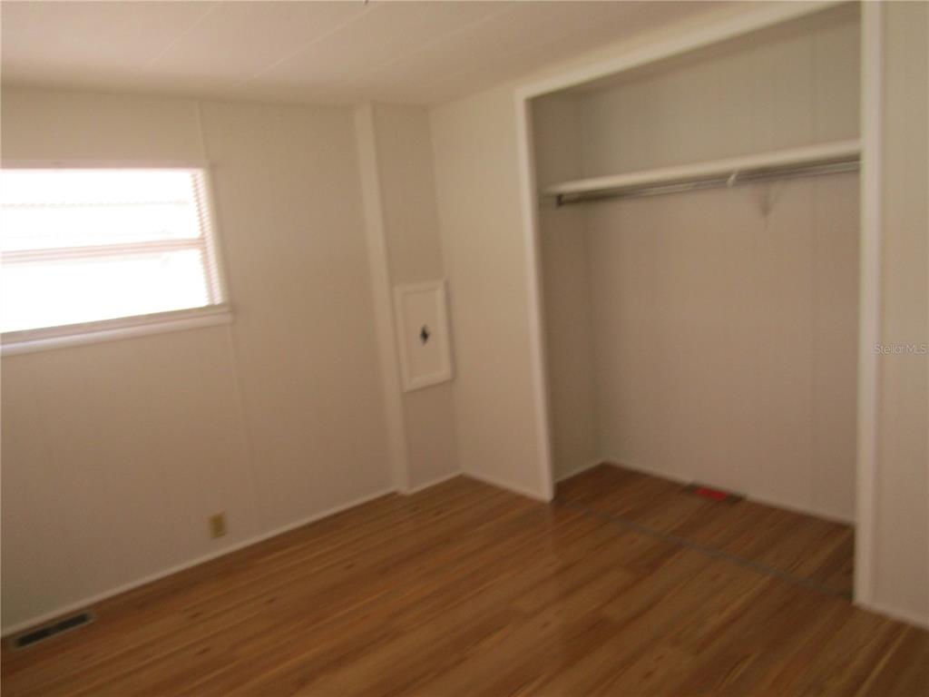 721 Roma Road Venice, FL 34285 - Photo 10 of 20 a view of an empty room with wooden floor and a window