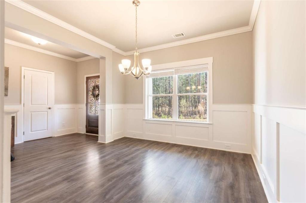 35 Hawthorn Lane Covington, GA 30014 - Photo 14 of 38 an empty room with wooden floor chandelier and windows
