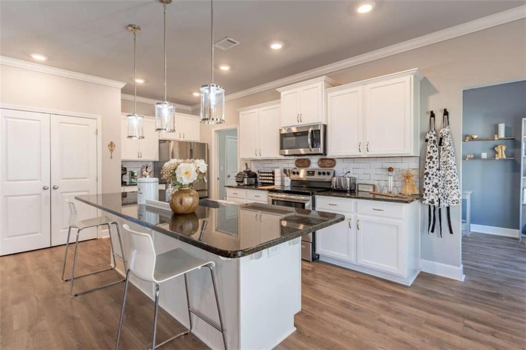 35 Hawthorn Lane Covington, GA 30014 - Photo 10 of 38 a kitchen with kitchen island granite countertop a sink appliances cabinets and a counter top space