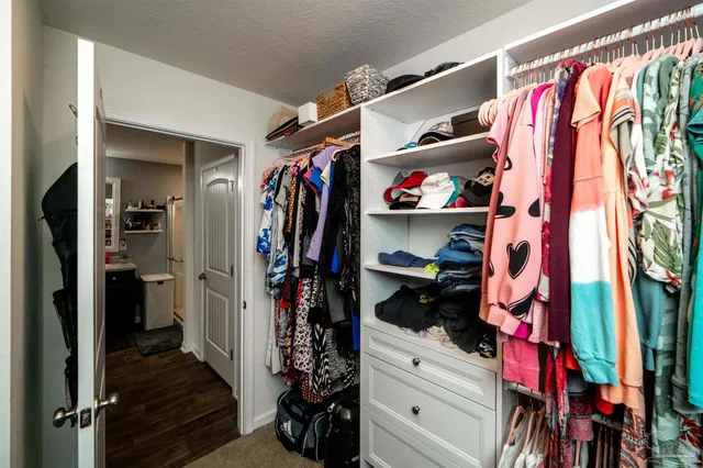 a view of walk in closet with clothes and shoes