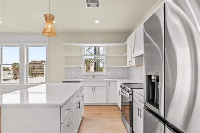 a kitchen with cabinets appliances a sink and a window