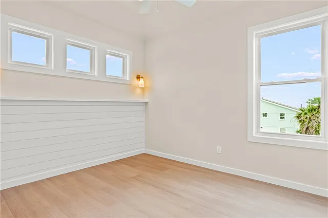 a view of empty room with wooden floor and cabinet