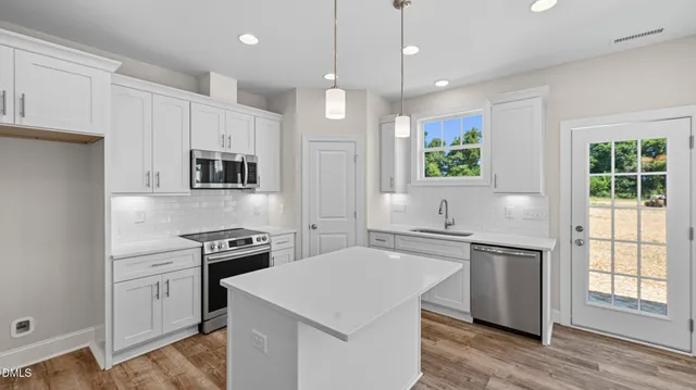 a kitchen with a stove a sink and a refrigerator