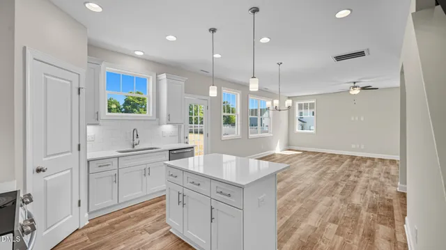 a large kitchen with kitchen island white cabinets and wooden floor